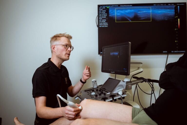 Fysiotherpaie er wordt een echo van een knie gemaakt